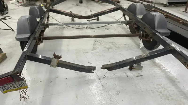 Rusted boat trailer frame with rear rails broken off, brought to Iron Mann Industries in Flint, MI for repair.