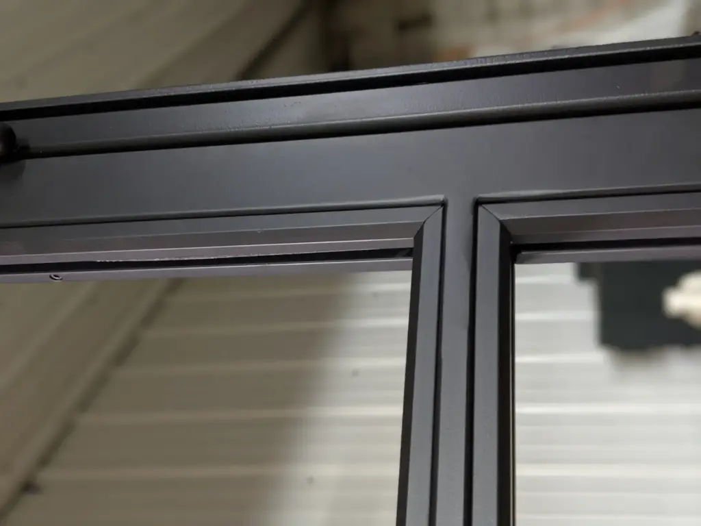 Finished matte black corner detail of a custom steel French door